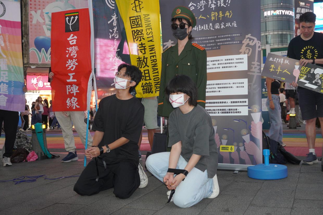  民團在西門町以行動劇表現已經被中共、港府聯手迫害的人民所受到的基本人權壓迫，要求中國與香港政府應立即無條件釋放鄒幸彤與李卓人，撤銷所有控罪。 圖：台灣人權促進會提供 