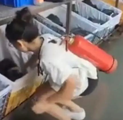  福建晉江一鞋廠發生火災之後，當地部分工廠有工人背滅火器上班。 圖：翻攝自 乾淨世界 影片 