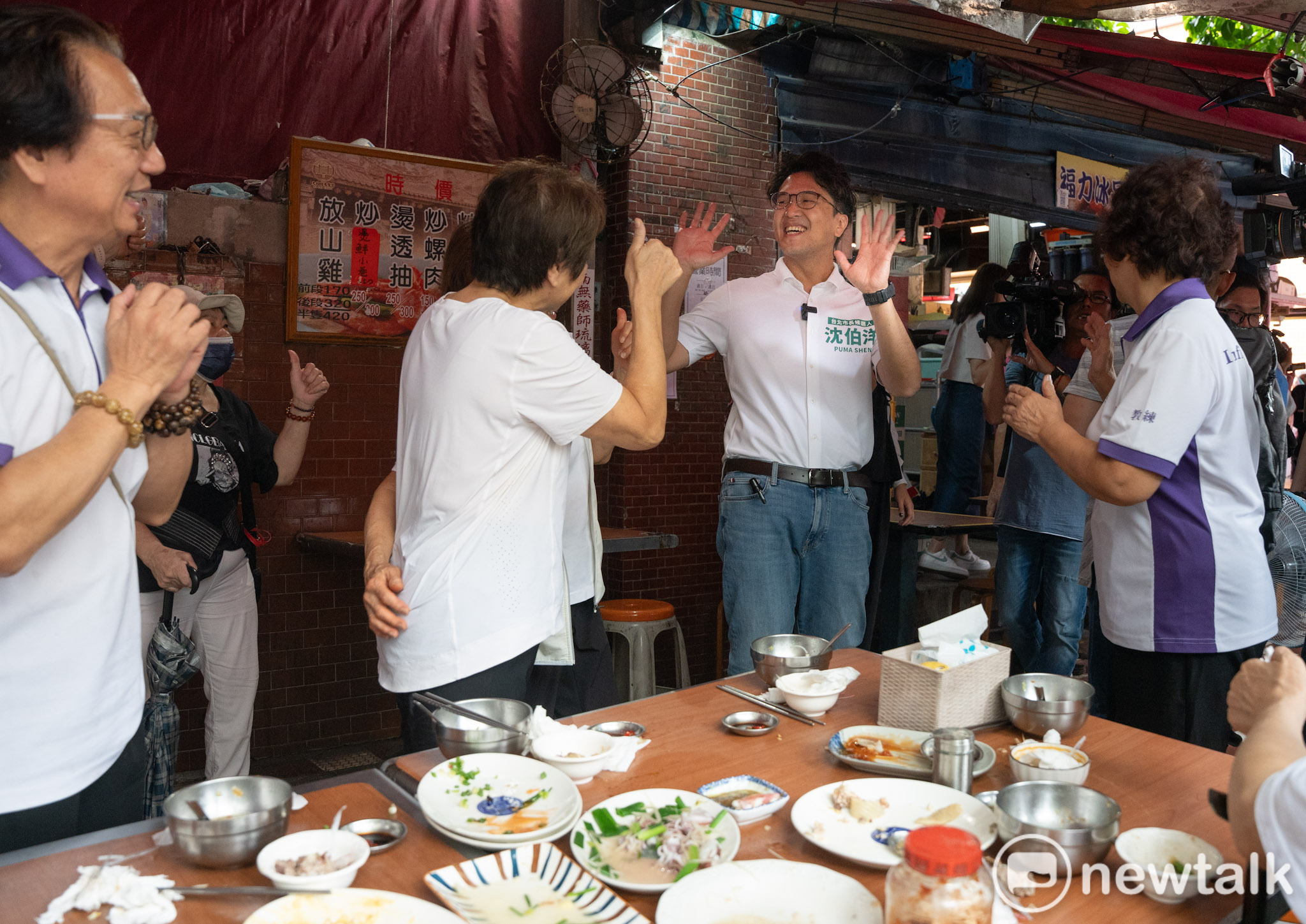  民進黨台北市長參選人沈伯洋到大稻埕慈聖宮參拜，並向廟前的攤商、吃飯的市民握手致意。 圖：張良一/攝 