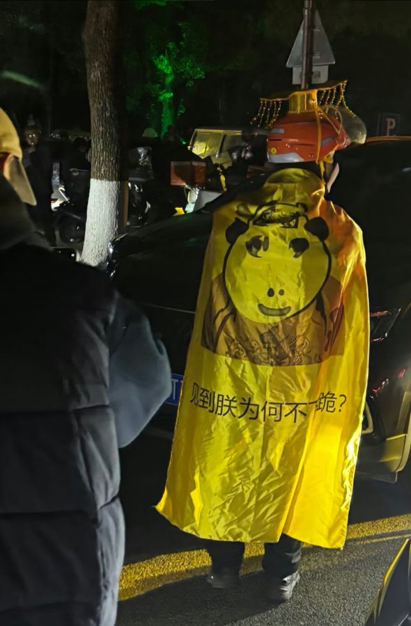 現場甚至出現騎手披上寫有「見到朕為何不跪」字樣的黃色披風，直接當場「黃袍加身」，在馬路中央繞行時，引發圍觀民眾鼓掌歡呼。圖 : 翻攝自X帳號@whyyoutouzhele