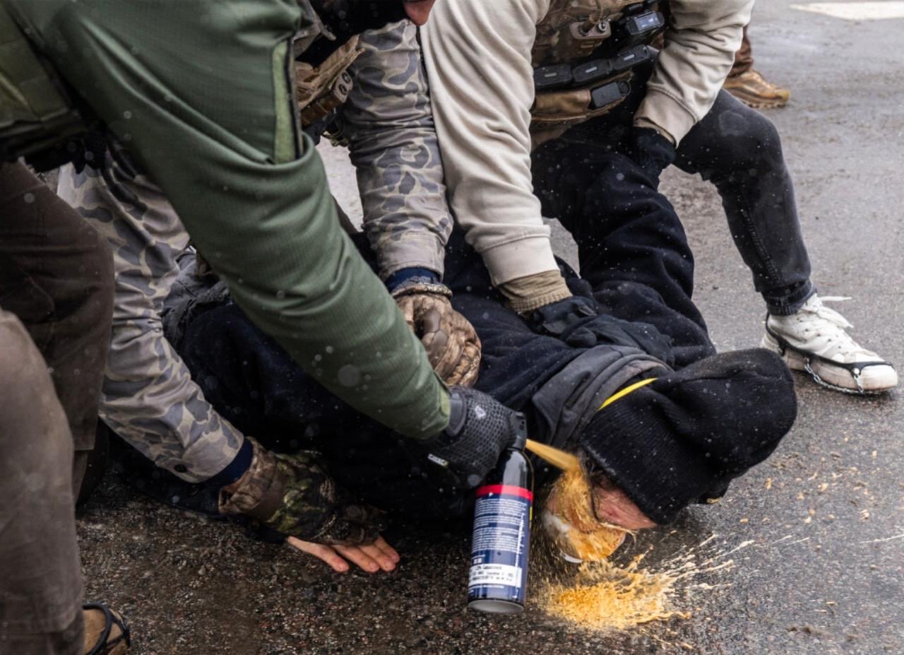  ICE 特工在街頭對遭壓制民眾朝臉部近距離噴射高濃度辣椒水。 圖：翻攝自 X 