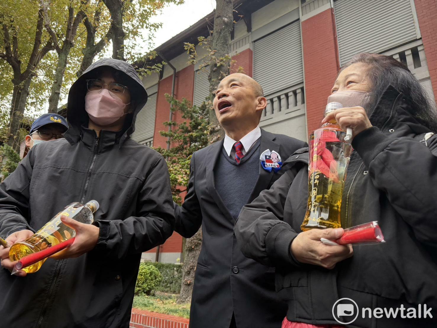 韓國瑜幫一對母子在立法院紀念酒上簽名。 圖：高逸帆／攝 