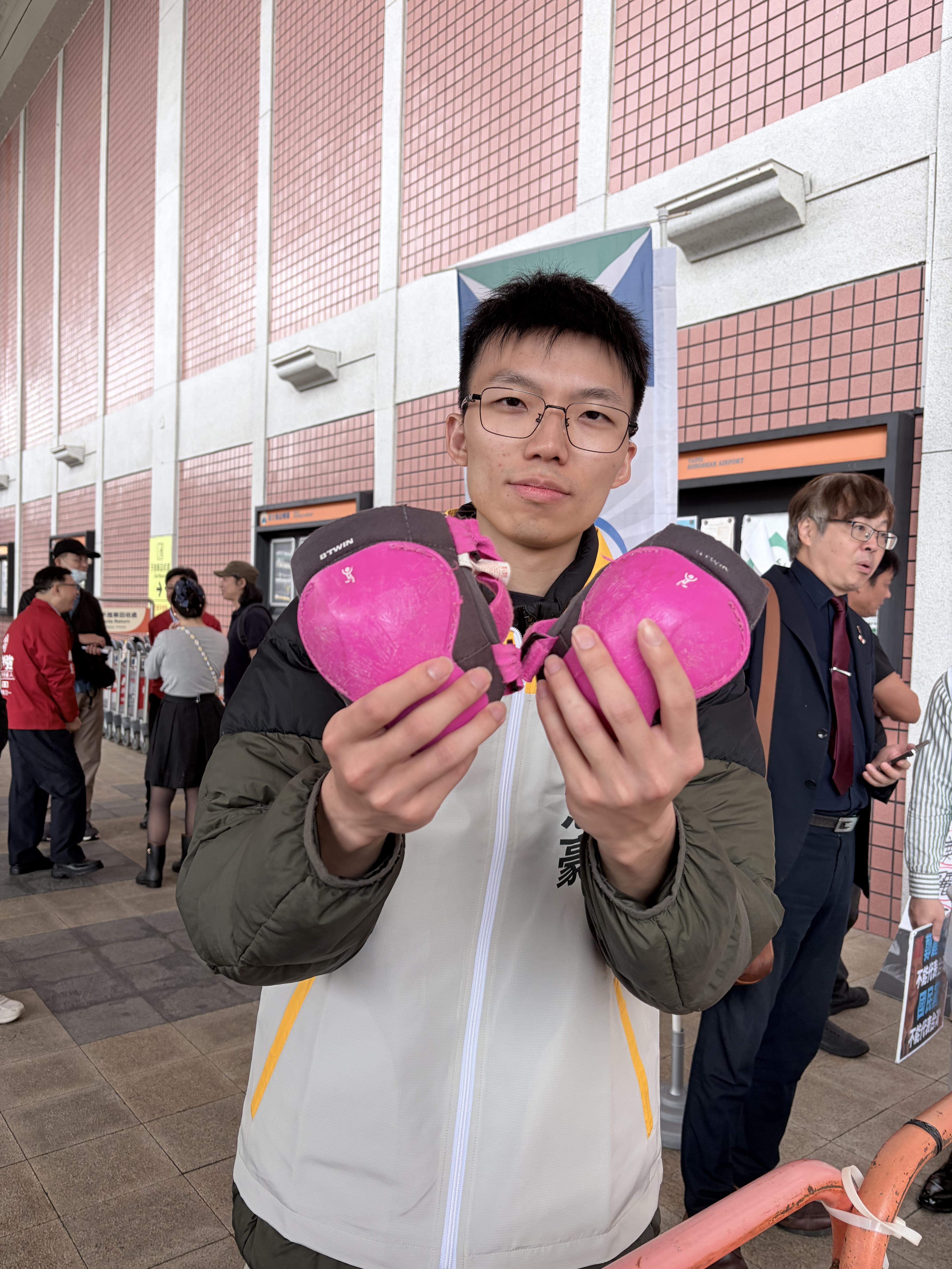  時代力量台北市士林、北投選區市議員參選人謝閔弘為國民黨主席鄭麗文送上「一對護膝」。 圖：李宣萱/攝 