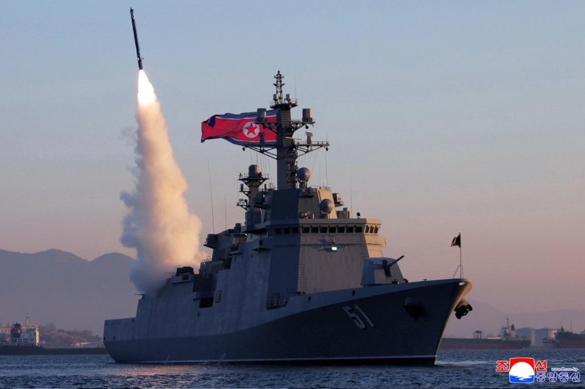  「崔賢號」驅逐艦試射 2 枚戰略巡航導彈與 3 枚反艦導彈。但背景可見岸上工業設施、山脈及港區建築，懷疑可能在港口內或近岸水域完成。 圖：翻攝朝中社