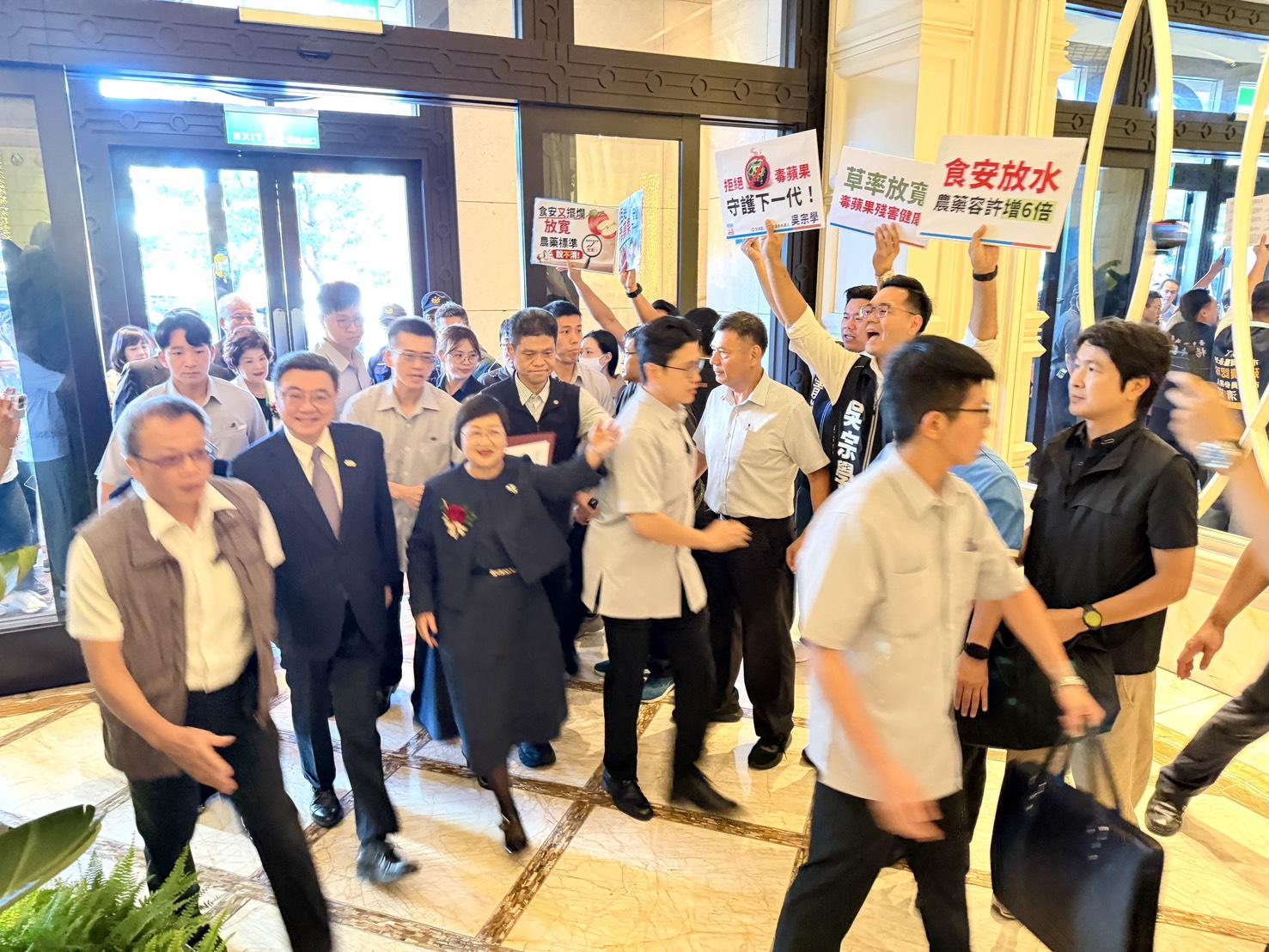 癌油事件爆發，社會大眾瀰漫著濃烈的民怨與不安，「漂浪島嶼」認為這正是國民黨發動「總攻」的絕佳契機。圖為行政院長卓榮泰台中林酒店出席活動。遭人舉牌抗議。 圖：吳宗學/提供 