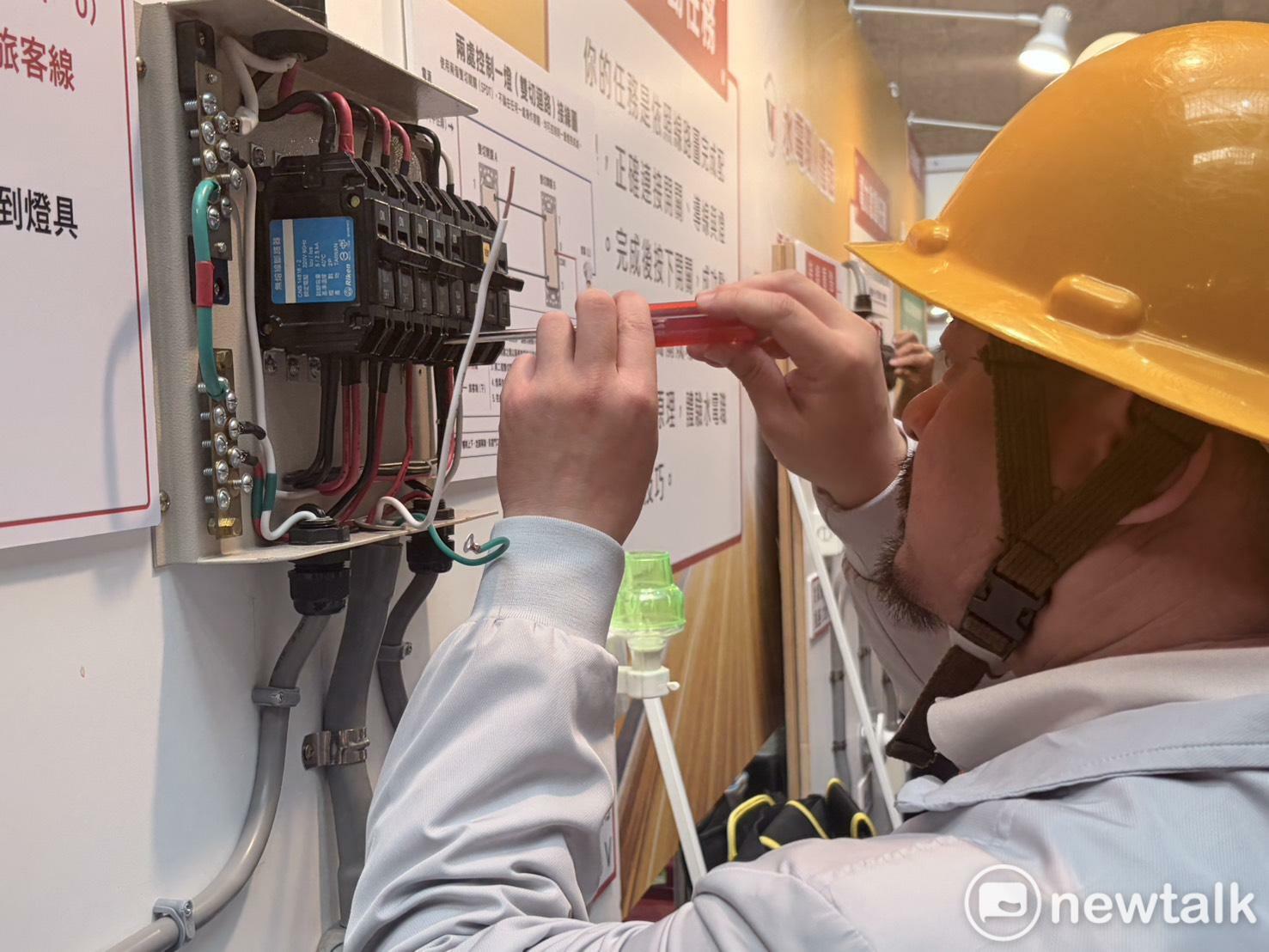  勞動部長洪申翰在活動中體驗水電工的接線技術。 圖：李宣萱/攝 