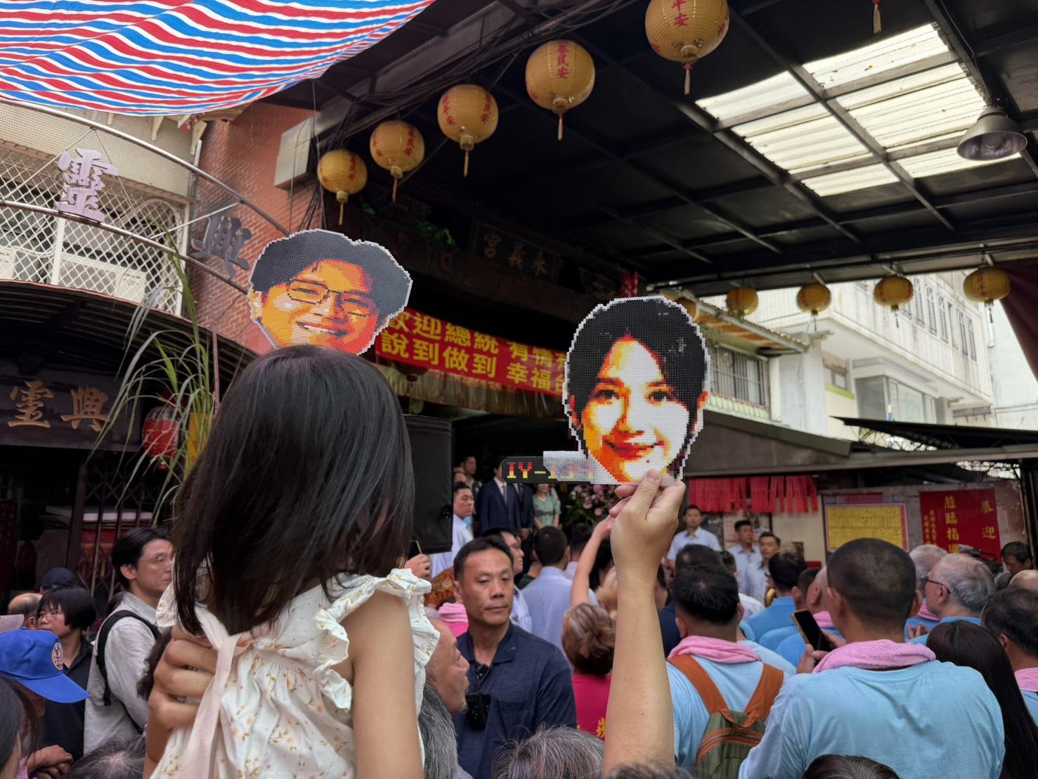 現場有小孩拿著沈伯洋與吳沛憶的點陣圖大頭照。 圖：高逸帆／攝 