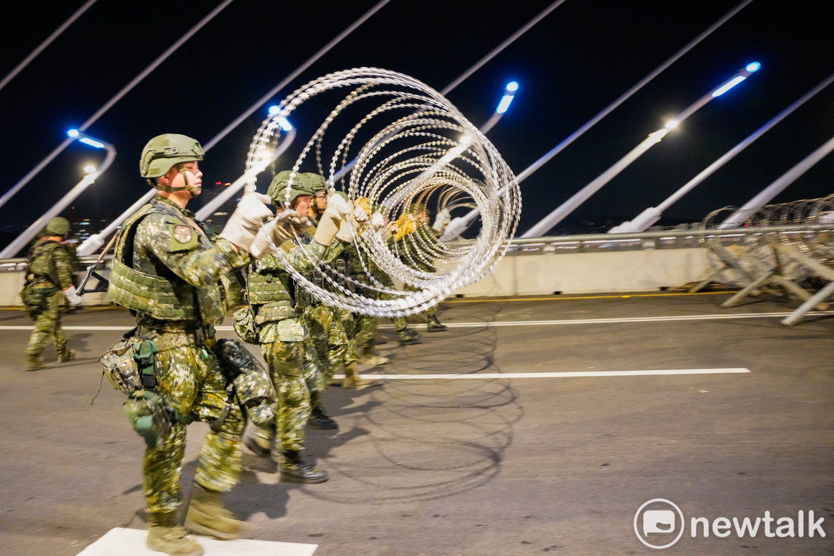  陸軍工兵群士兵在淡江大橋上設置鐵刺蝟，並綁上鐵絲網，延緩假想敵攻擊時間。 圖：張良一/攝 
