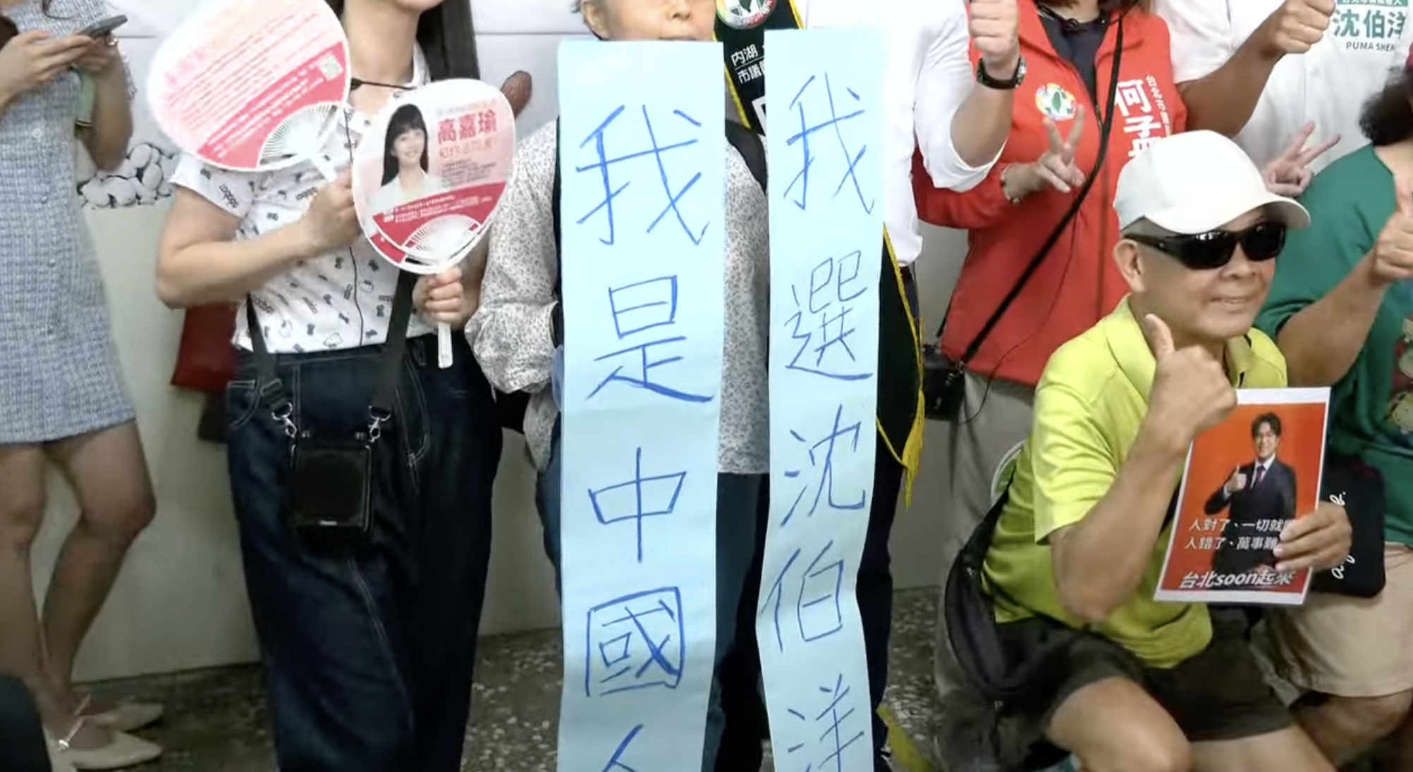  沈伯洋赴「南港成德市場」掃街，有民眾舉「我是中國人，我選沈伯洋」標語。 圖：翻攝自共訊 