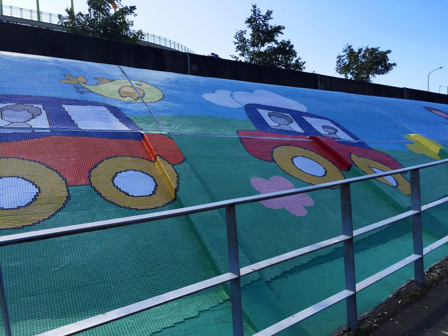 兒童新樂園堤外壁以童趣為主題，使原本單調的牆面煥然一新，歡迎大家來兒童樂園遊玩時，順路來此欣賞當地堤壁，停留休息兼觀賞。   圖：台北市政府提供