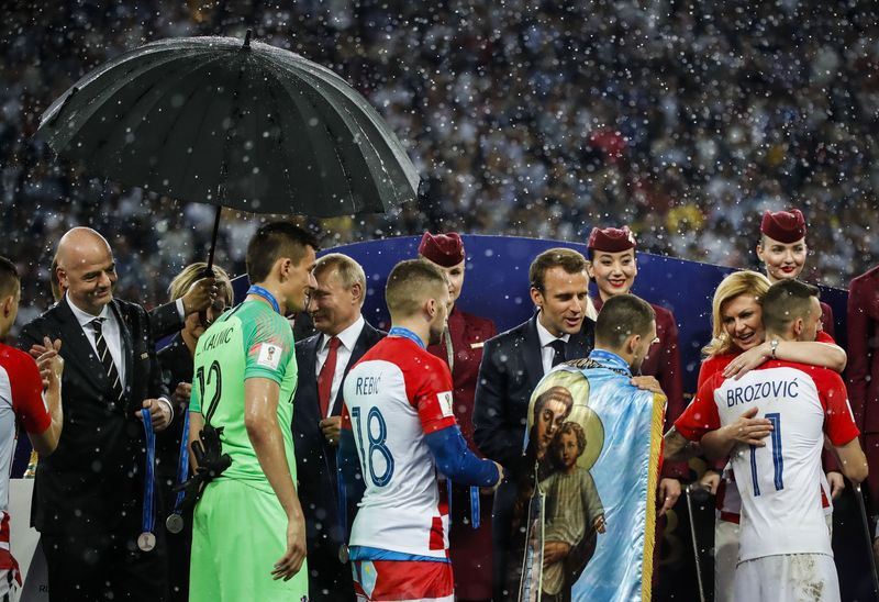 「世足賽最美的一幕：大雨傾盆卻沒雨傘。雖然輸球，季塔洛維奇（中排右）還是把克羅埃亞和法國的每一位球員一一擁入懷中。那是溫暖親切的真情流露。擺脫政治，只有運動！恭喜兩隊！」，社群媒體上的上述留言，說得十分貼切。   圖：達志影像/路透社