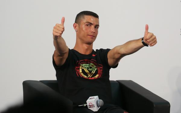 目前正在中國訪問的葡萄牙足球巨星C.羅（Cristiano Ronald）19日在北京出席活動並接受媒體採訪，還與小球員互動。    圖：新華社