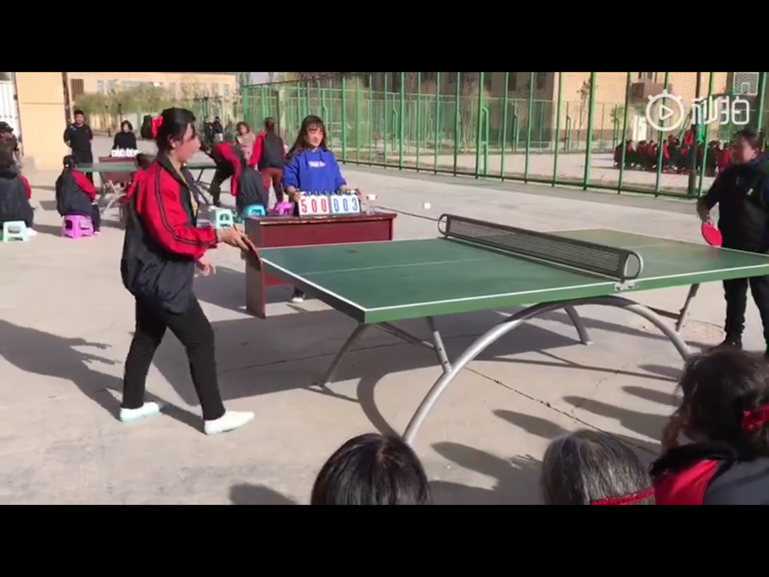 這段影片時間長1分54秒，映入眼簾的是，在多棟黃色大樓外的操場上，許多穿著制服的維吾爾族女子放風到戶外，打桌球、籃球。   圖：翻攝自胡錫進微博