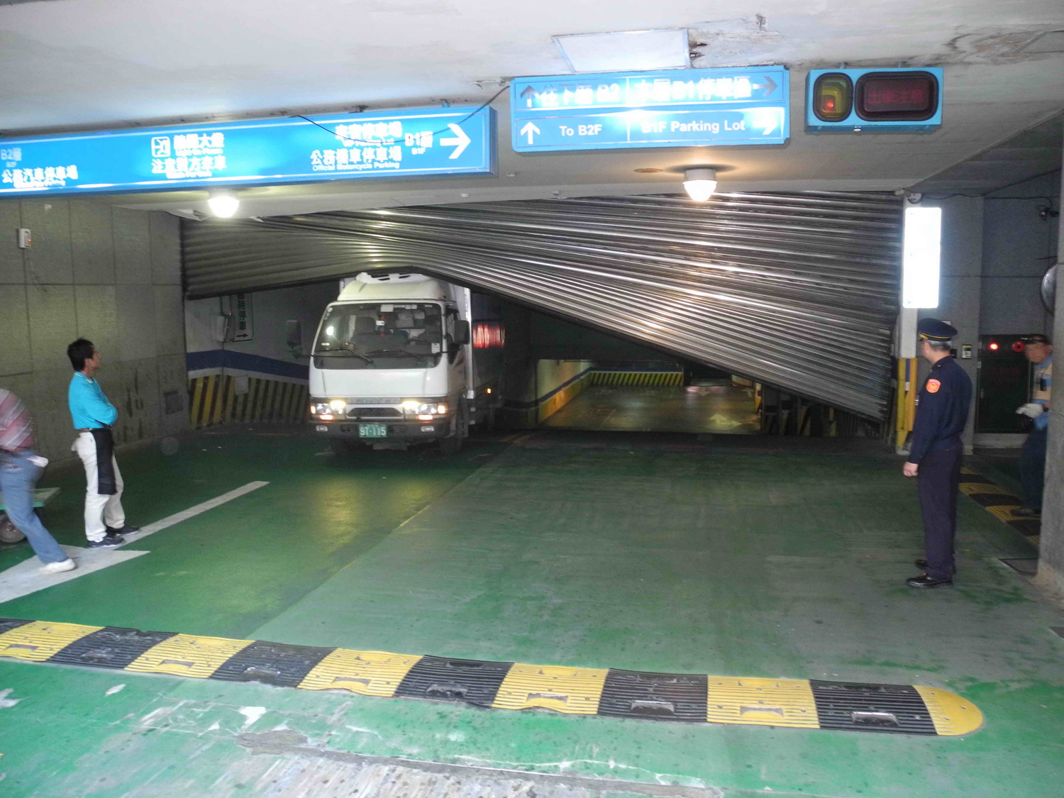 新北市府地下停車場B2到B1的西側入口處大型鐵捲門，今早突然墜落砸中冷凍車，西側車道整個封閉。    圖：王峻昌/攝