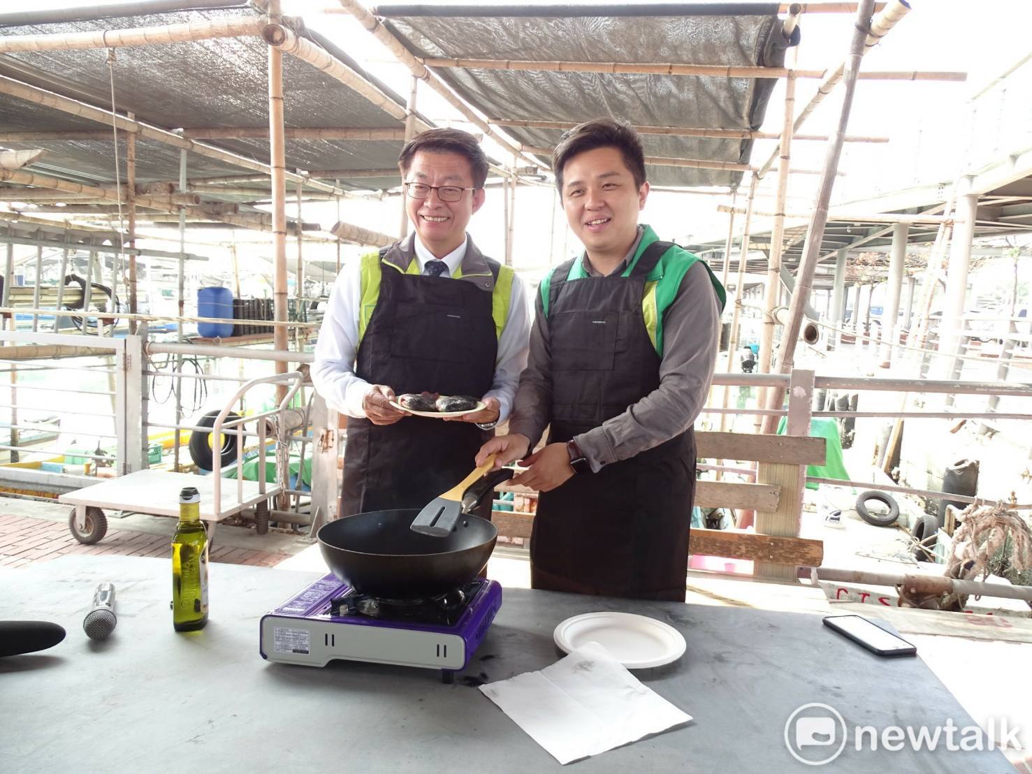 男打扮的郭國文與市議員李啟維一同端出「香煎吳郭魚」，為台南的養殖漁業提出不同的南向政策。   圖：黃博郎攝