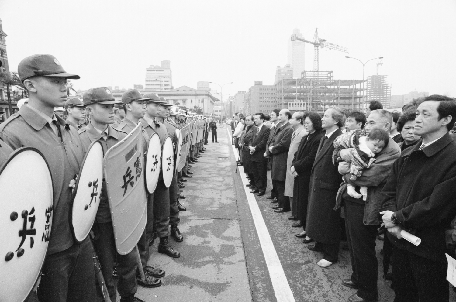 1996年2月28日，林義雄前往總統府前為二二八受難者默哀時與憲兵對峙，高俊明牧師陪著林義雄律師站在鎮暴部隊前，毫無所懼。   圖：邱萬興/攝