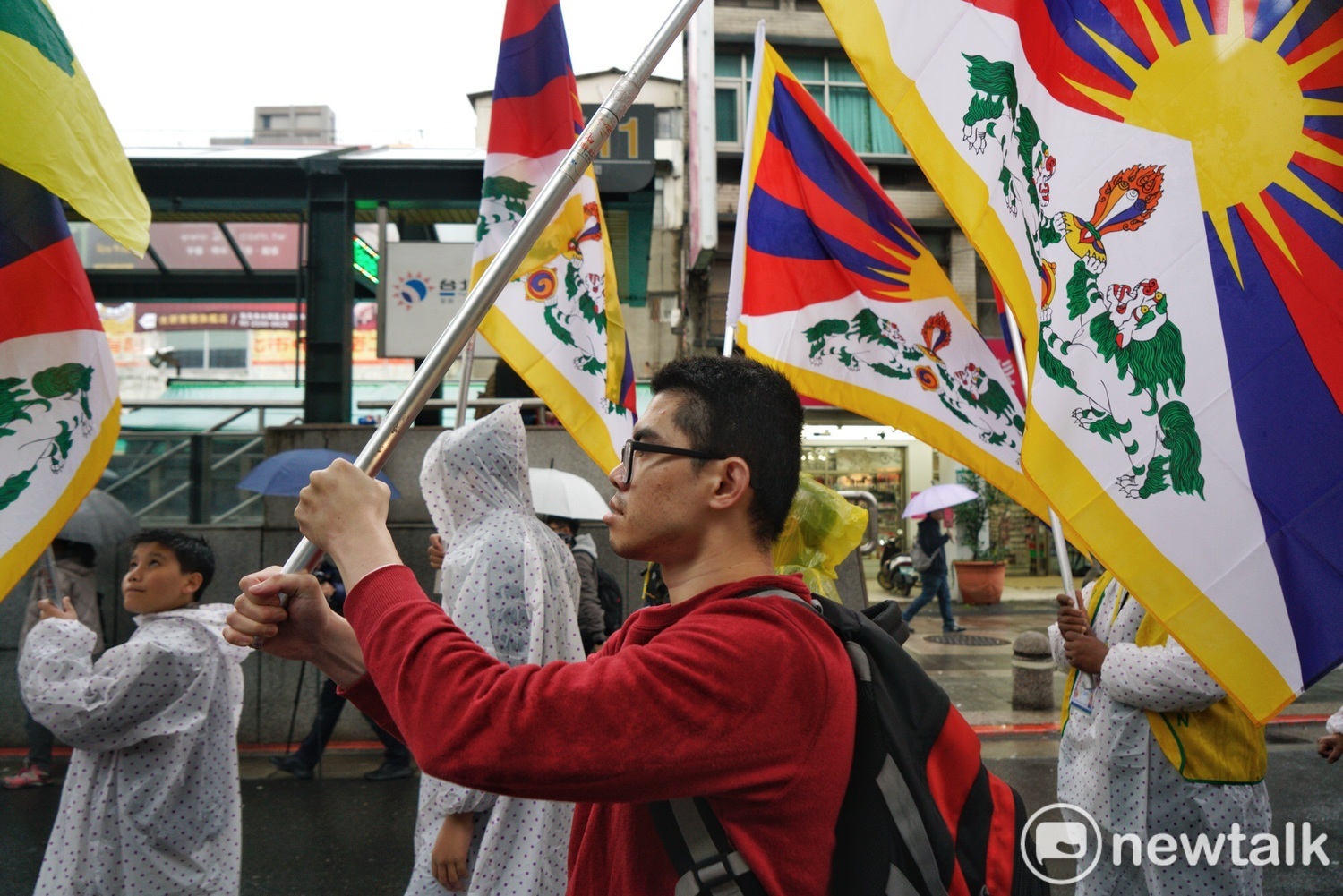 超過百位來自各地的藏人及支持者在大雨中揮舞表藏族的旗幟遊行，表達爭取藏族自由。   圖：張良一／攝
