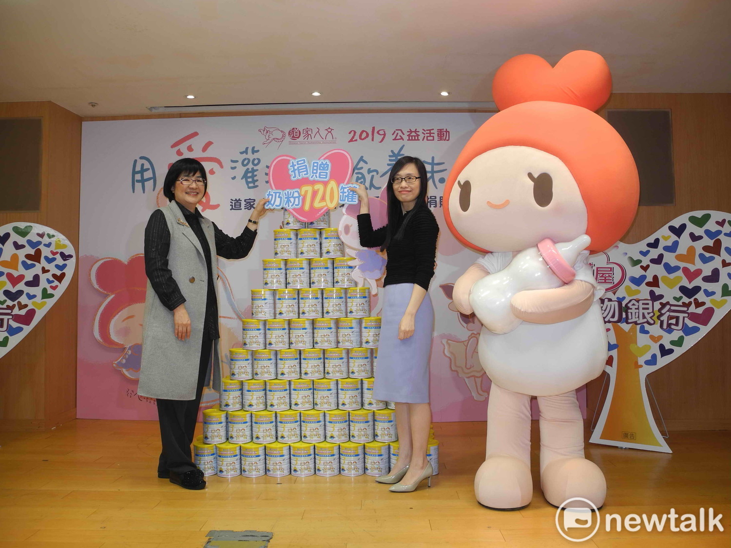 中華道家人文協會理事長張旖（右）捐贈720罐奶粉給新北市，由社會局長張錦麗代表受贈。   圖：王峻昌/攝