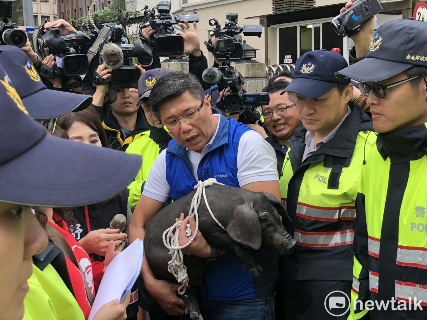 新北市議員陳明義抱小豬和警方溝通。   圖：謝莉慧/攝