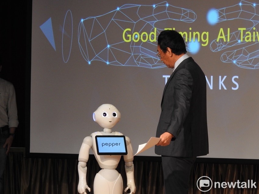 郭台銘也在台上與自家的AI進行互動，聽到AI說「2020郭台銘，AI台灣；2020郭台銘，愛台灣」，郭輕拍AI的頭喊不錯後走下舞台。   圖：趙婉淳／攝