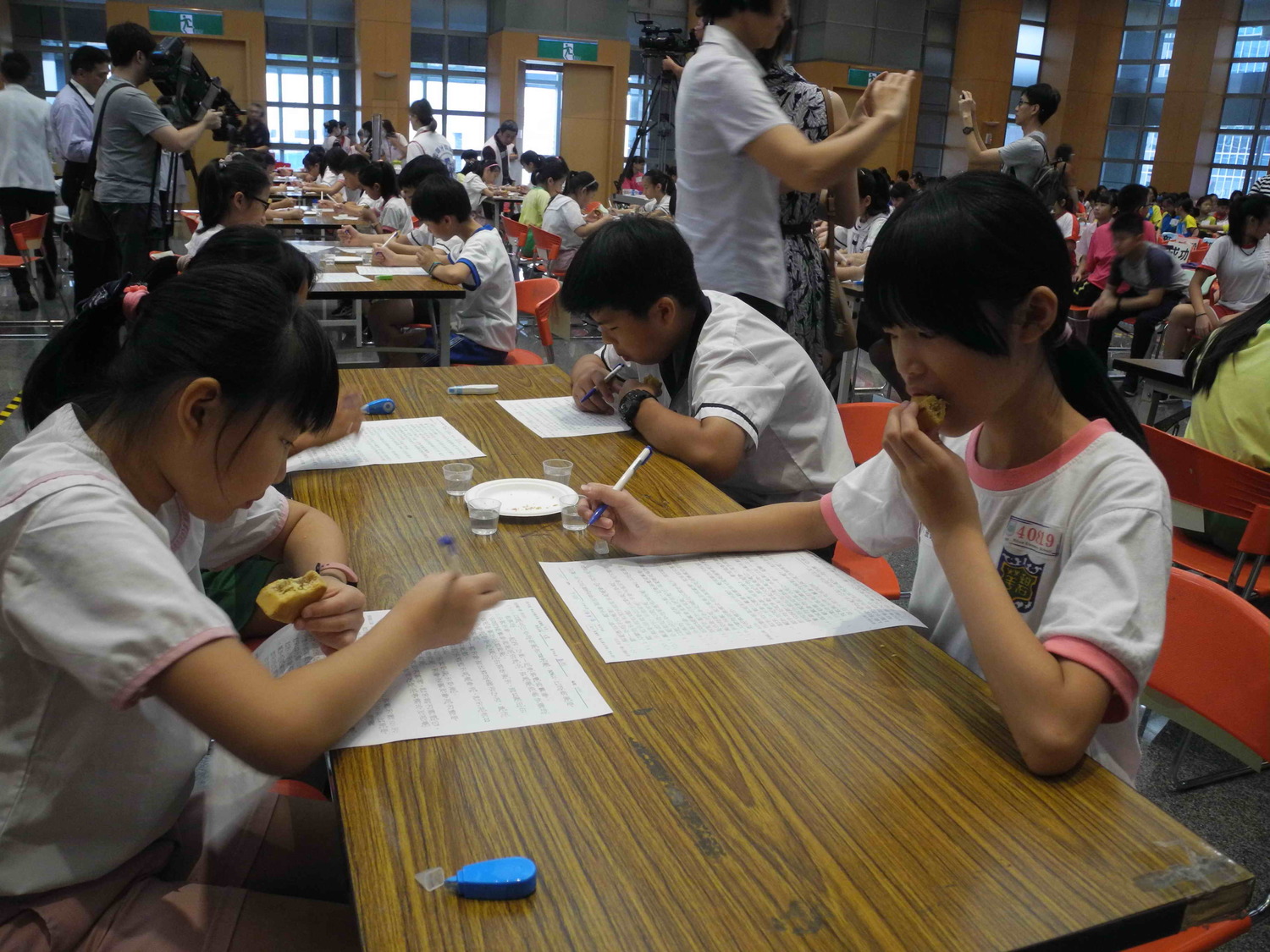 參加潔牙比賽的小朋友先吃鳳梨酥，同時填寫潔牙知識測驗卷。    圖：王峻昌／攝