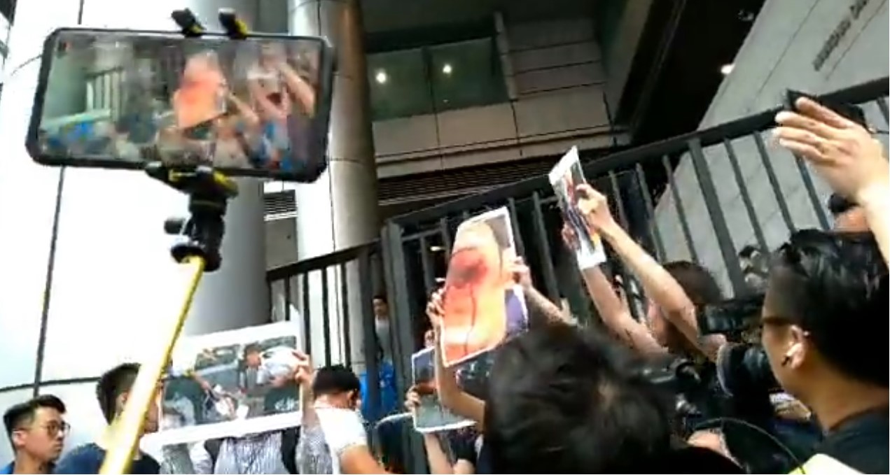 近百名抗議民眾聚集香港警察總部前，要求律政司針對「612反送中暴動」回應負責，還不斷疾呼要警務處處長盧偉聰及保安局局長李家超下台。   圖：翻攝自社會民主連線臉書