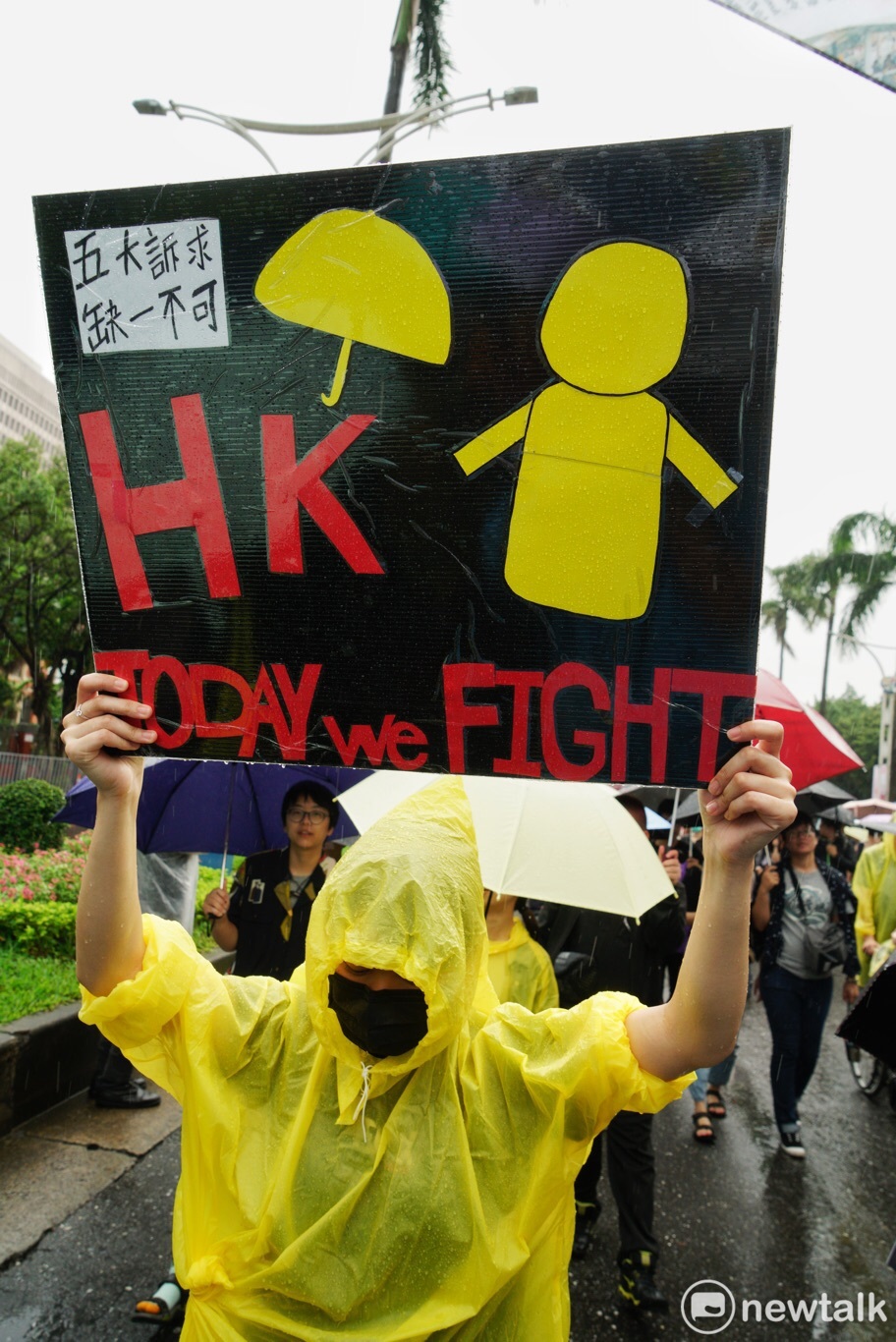 「929撐港大遊行」中，一名身穿輕便雨衣的民眾，高舉「五大訴求，缺一不可」的牌子，更強調「TODAY WE FIGHT」的精神。   圖：張良一/攝