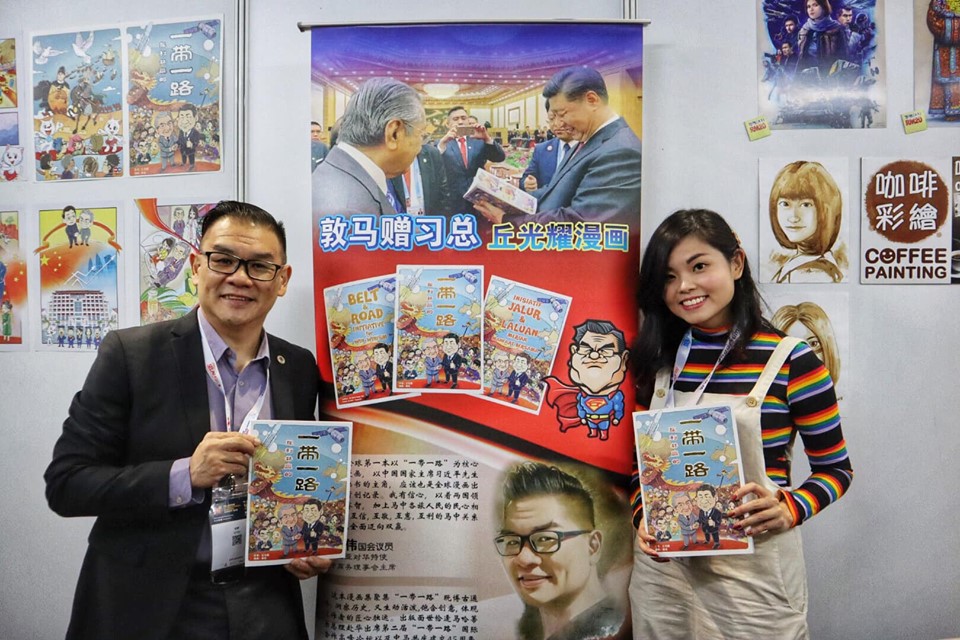 馬中商務理事會丘光耀（左）主編、漫畫家張寶玲繪製的馬來西亞《互利共贏的一帶一路》漫畫，因滲入校園，遭到查禁。   圖：翻攝自張寶玲臉書