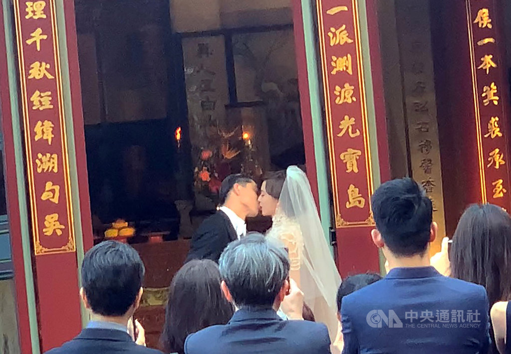藝人林志玲（後右）和日本男星AKIRA（後左）17日下午在台南市中西區全台吳姓大宗祠舉行婚禮，兩人在親友團前甜蜜親吻，宣誓攜手終身。   圖：中央社提供