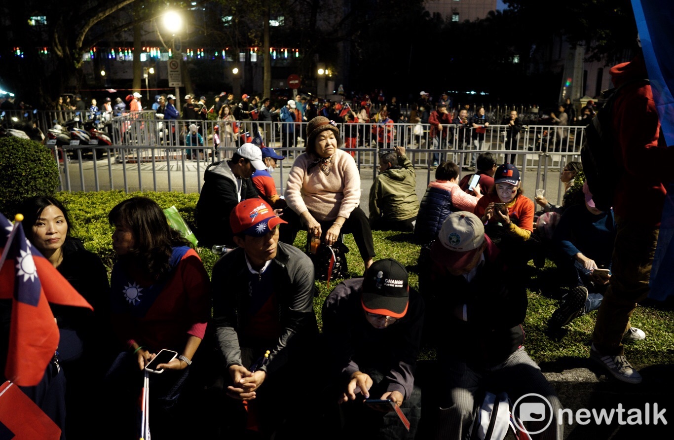 草地上有些人席地而坐、有些人自備椅子，在寒風中期待韓國瑜到來。   圖：張良一/攝