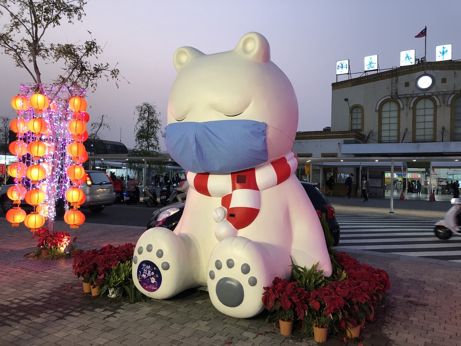 嘉義火車站前的裝置藝術沈睡大白熊戴上口罩，提醒民眾注意防疫。   圖：嘉義市政府/提供