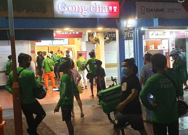 新加坡下令21日晚間11時59分起暫時關閉飲料店，昨晚珍珠奶茶店外聚集許多外送員。   圖：翻攝自Twitter