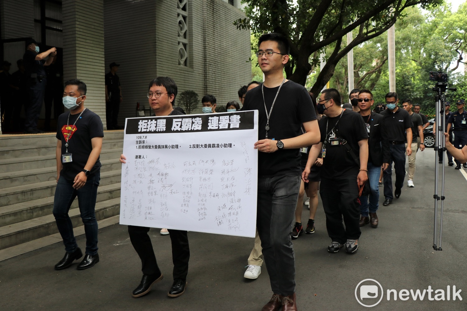 國民黨助理在「拒抹黑、反霸凌」連署書上千名，並繞行議場一圈。   圖：謝孟華/攝