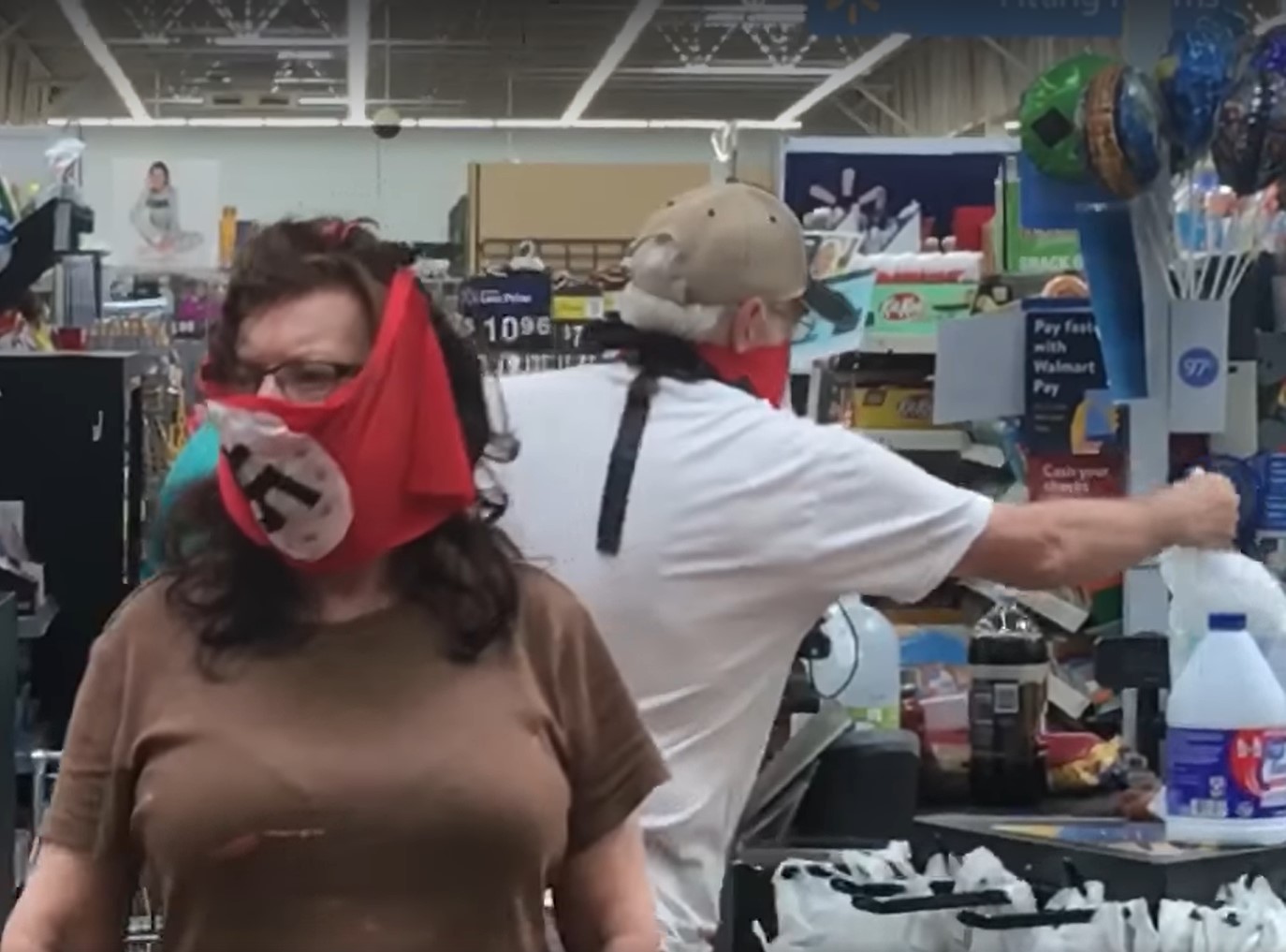 有兩人在逛明尼蘇達州的沃爾瑪商店時，臉戴印有納粹卍字的口罩。   圖：截取自繆勒臉書影片
