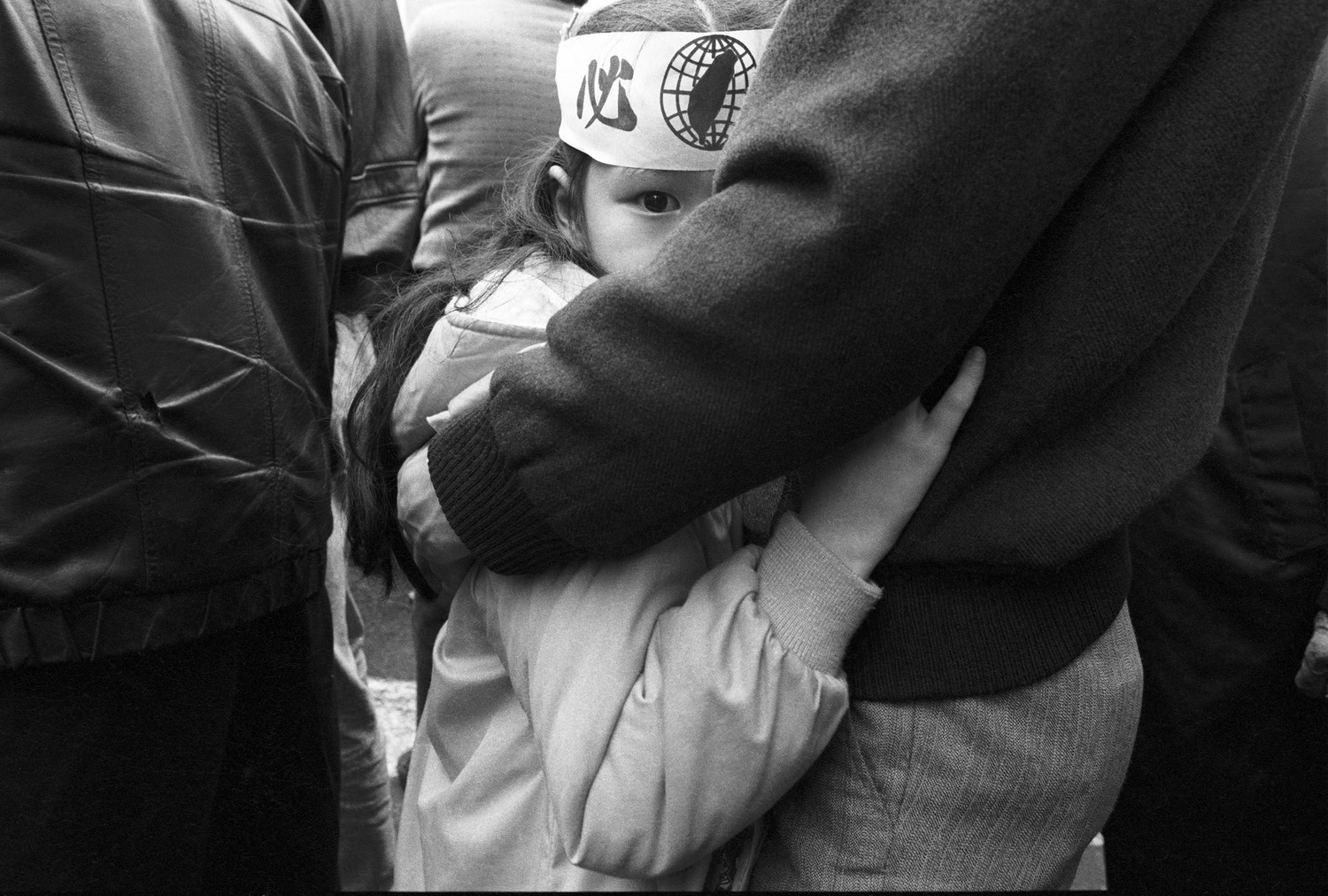 1989年12月，中山堂內國民大會舉行集會，場外民主阿草們抗議萬民國會老法統，一位小女孩依偎在父親的懷裡張望。   圖：杭大鵬／攝