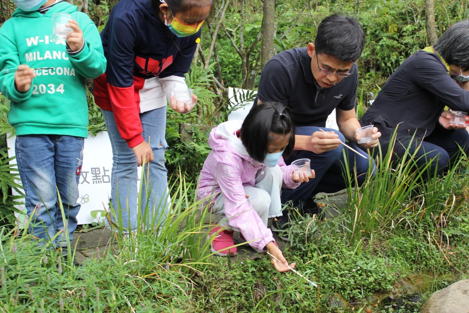 農業局副局長徐開宇陪學童親手將螢火蟲幼蟲野放至池塘。    圖：新北市農業局／提供