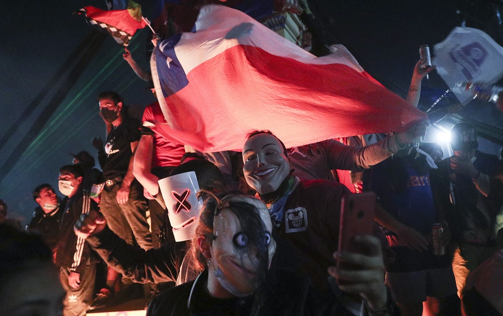 智利民眾25日舉行制憲公投，以壓倒性票數支持制定新憲法，首都聖地牙哥民眾瘋狂慶祝公投結果。   圖：達志影像／美聯社