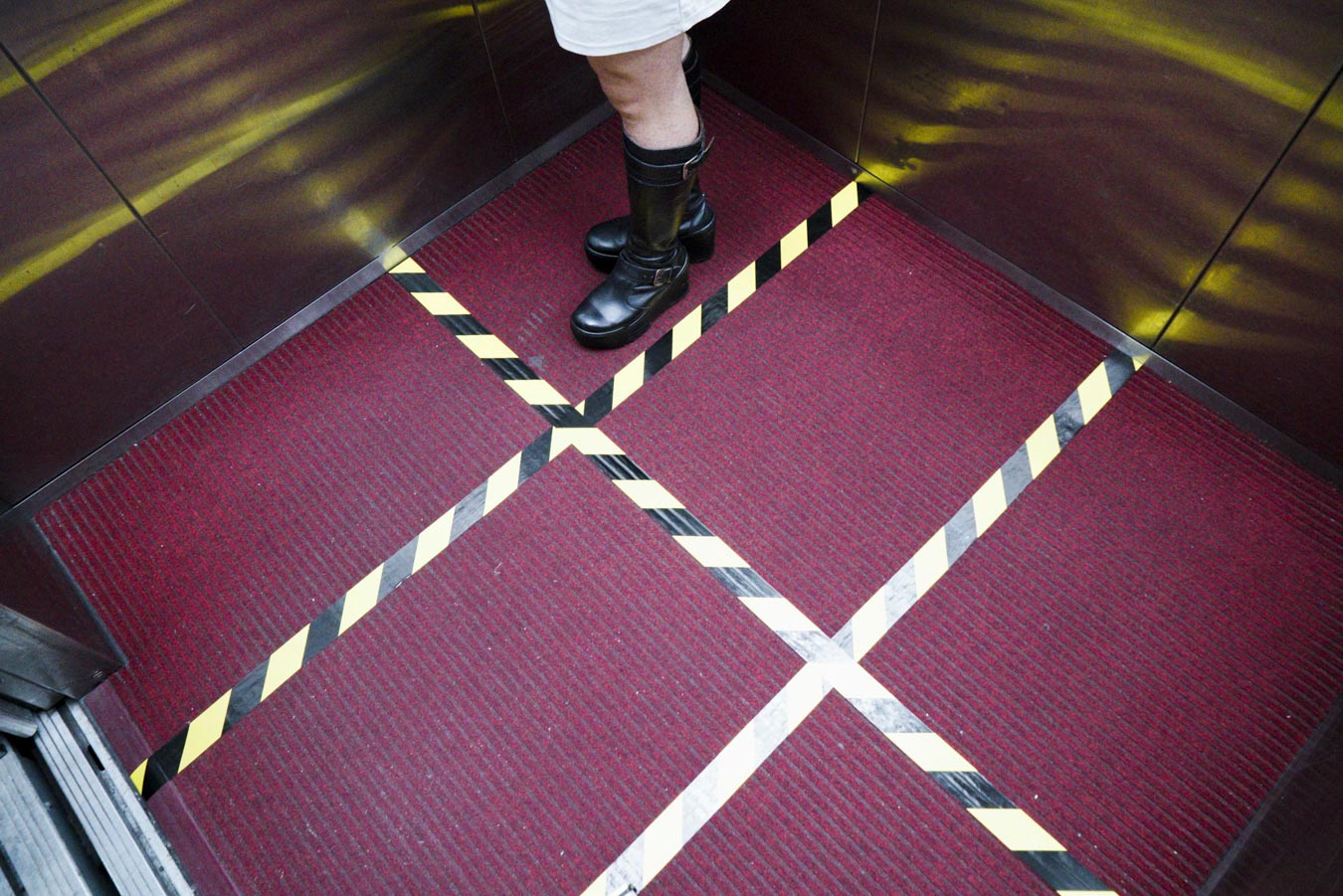 武漢肺炎疫情爆發，立法院的電梯地板被黃色膠帶區分成六格，並限定一次只有六人可搭乘，以預防被病毒交叉感染。圖：張良一/攝