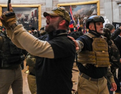 1月6日衝進議場的川粉暴動者身穿防彈衣，在國會大廳拍照。   圖：翻攝自DC Police Department推特