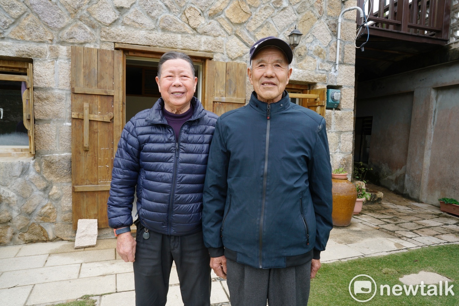 曹嫩妹(左)和曹惠惠兩人在曹嫩妹的老家前合影。他們兩人年輕時一起在大浦打漁,馬祖魚少後,曹嫩妹舉家遷往台灣,曹惠惠則幫到大坪村居住。曹嫩妹的女兒曹鳳金透露,馬祖早年生活困苦,需要男丁幫手,因此會用較女性化的名字幫男孩命名,以避免遭天忌夭折。 圖:張良一/攝