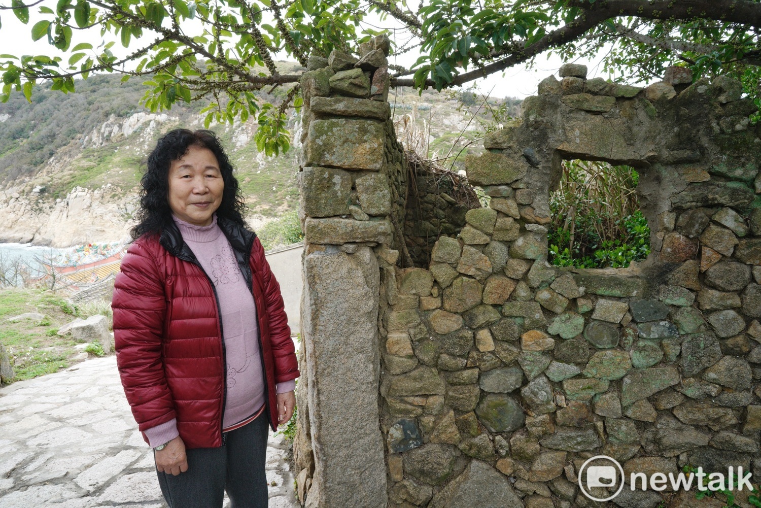 劉美珍在她的老家前合影。劉美珍說,她身旁的石頭屋是她公公的房間,當時她和先生、公公和五個孩子就擠在小小的屋子生活。她們後來舉家遷往台灣,近年看她的好姐妹王明恩的女兒把老家改建作民宿作得有聲有色,也興起了改建老家的念頭。 圖:張良一/攝