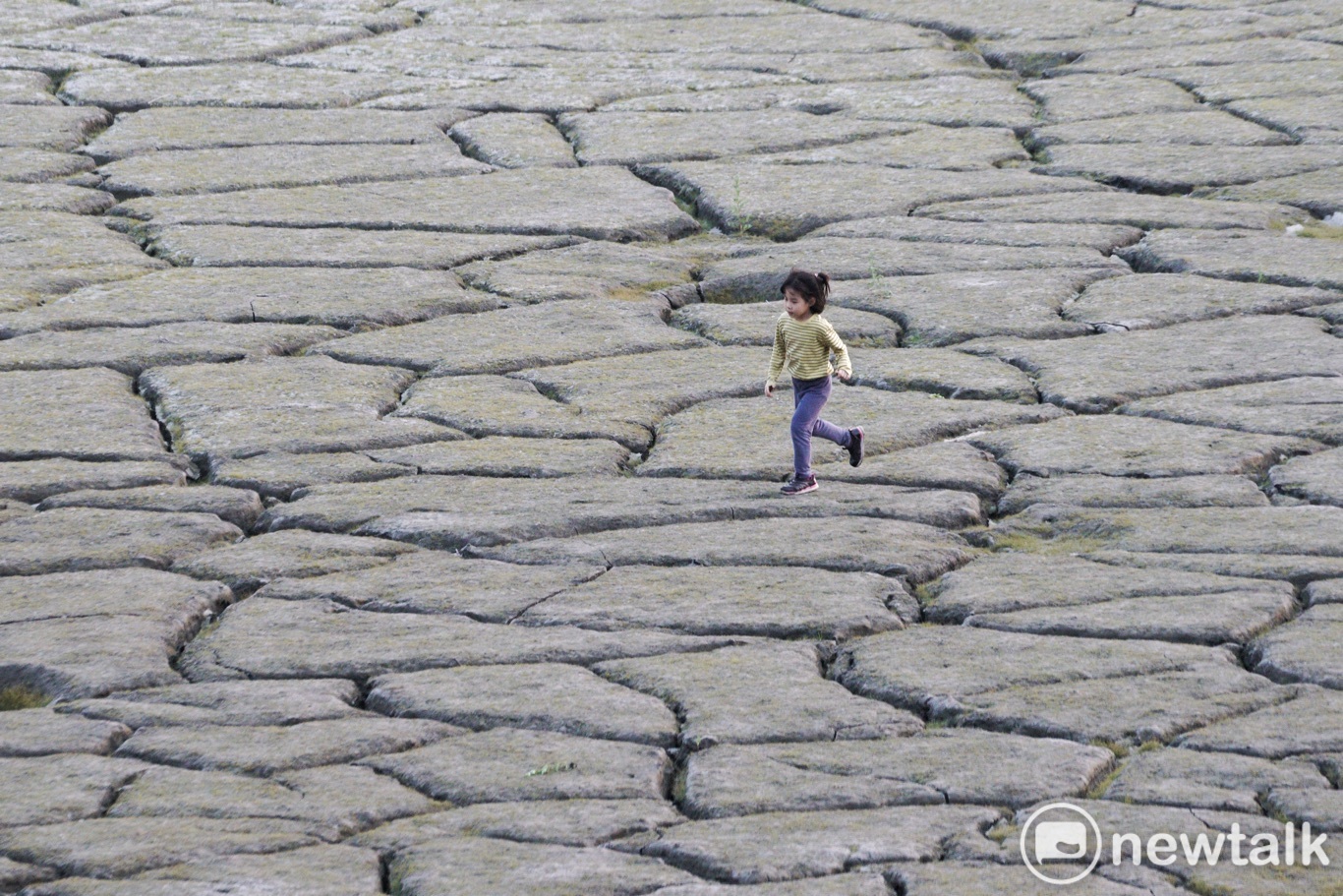 一位小朋友在日月潭大竹湖附近龜裂的湖底奔跑。   圖：張良一/攝