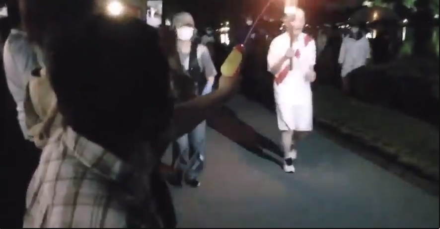 (影) 高喊反奧運口號 日本大嬸用水槍噴火炬手 遭現場逮捕