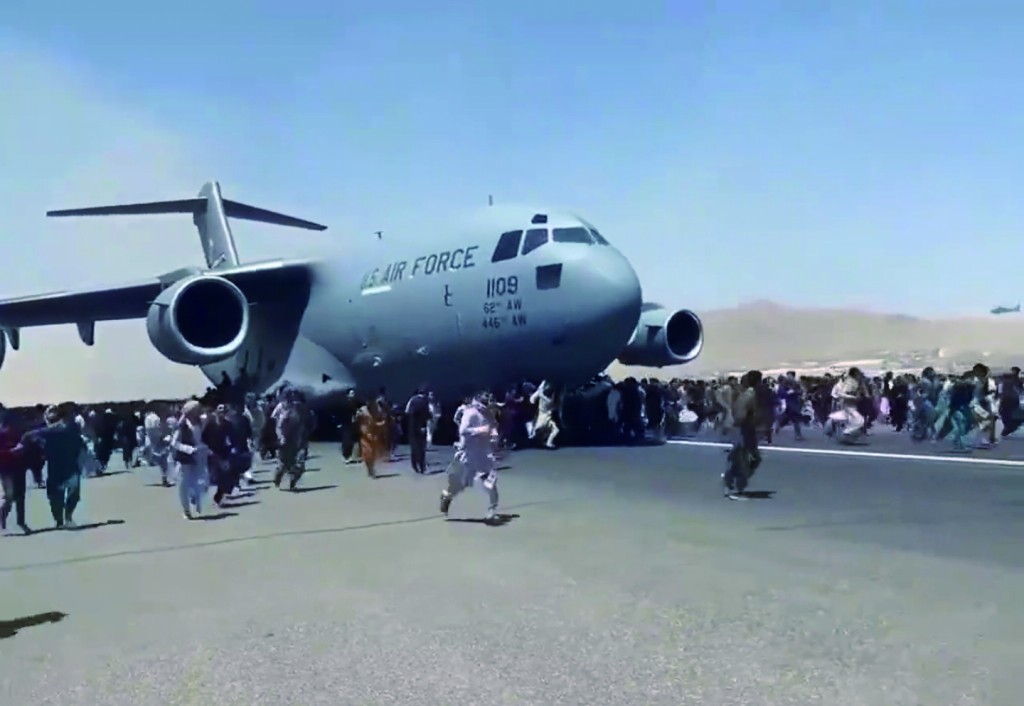 無法跟著美國軍機離開的阿富汗公民，在機場上圍繞著飛機跟著跑。阿富汗撤軍的混亂，讓美國在全球顏面盡失。   圖 : 翻攝自環球網