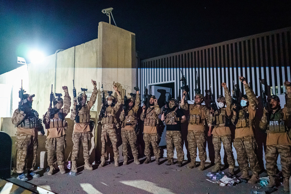 穿著美軍裝備的塔利班部隊在喀布爾機場門口鳴槍慶祝美軍離開，並高呼口號。   圖 : 翻攝視覺中國