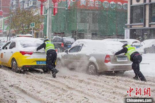 暴雪、寒潮狂襲中國大陸，多省發布緊急通知：停課！停運！停航！圖為車輛受困道路，警察協助排除。   圖：翻攝中新網