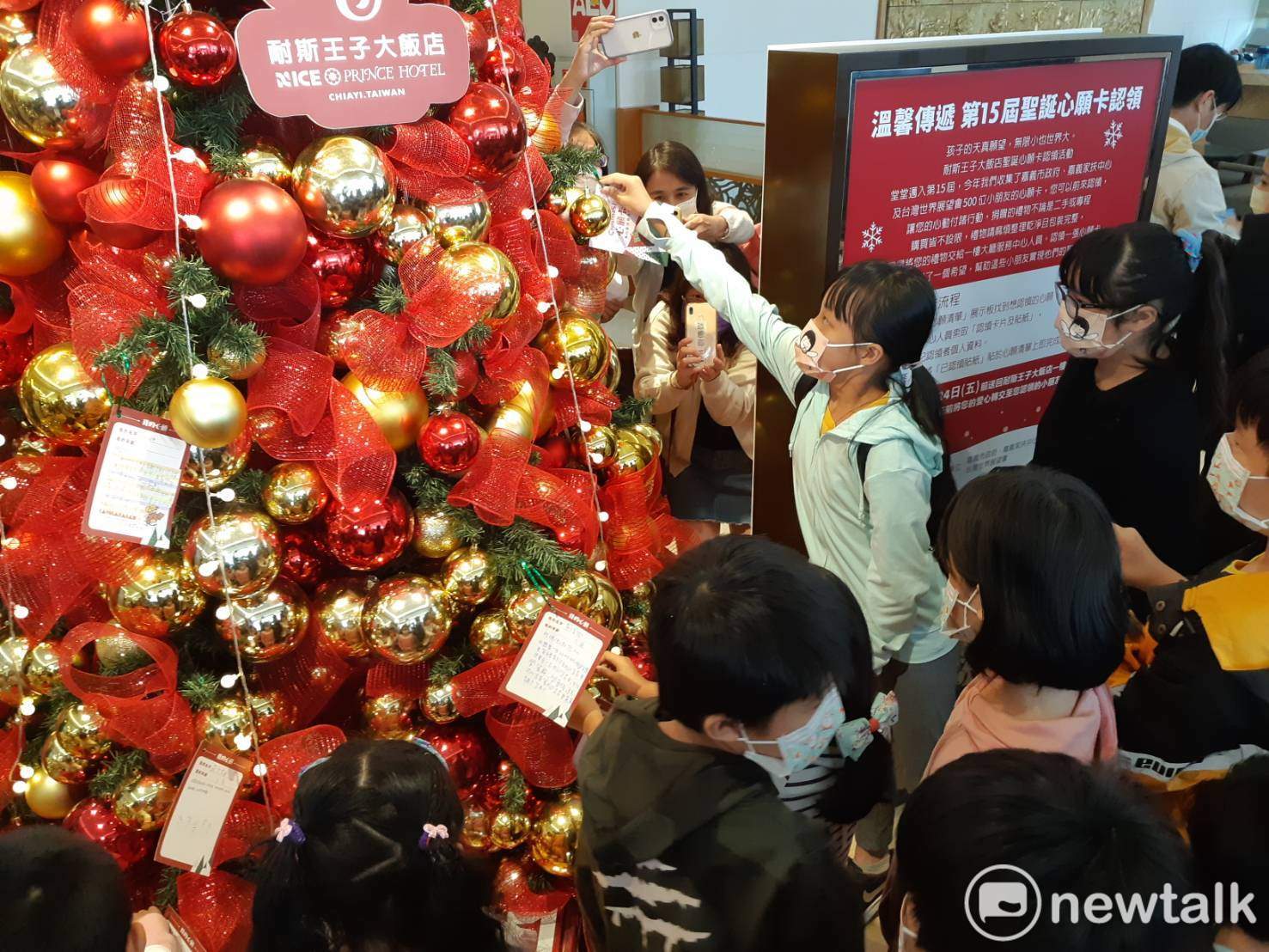 嘉義耐斯王子大飯店聖誕心願卡活動起跑，小朋友在聖誕樹上掛上自己的心願卡。   圖：蔡坤龍/攝