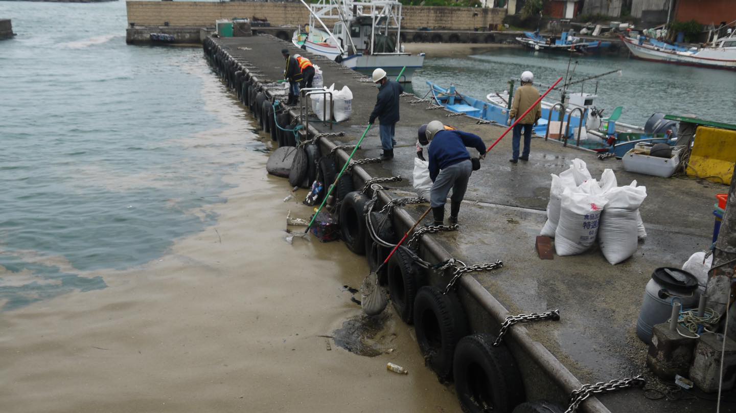 台灣漁港遭火山浮石「入侵」，漁民在港邊打撈清理。   圖：翻攝蔡適應臉書