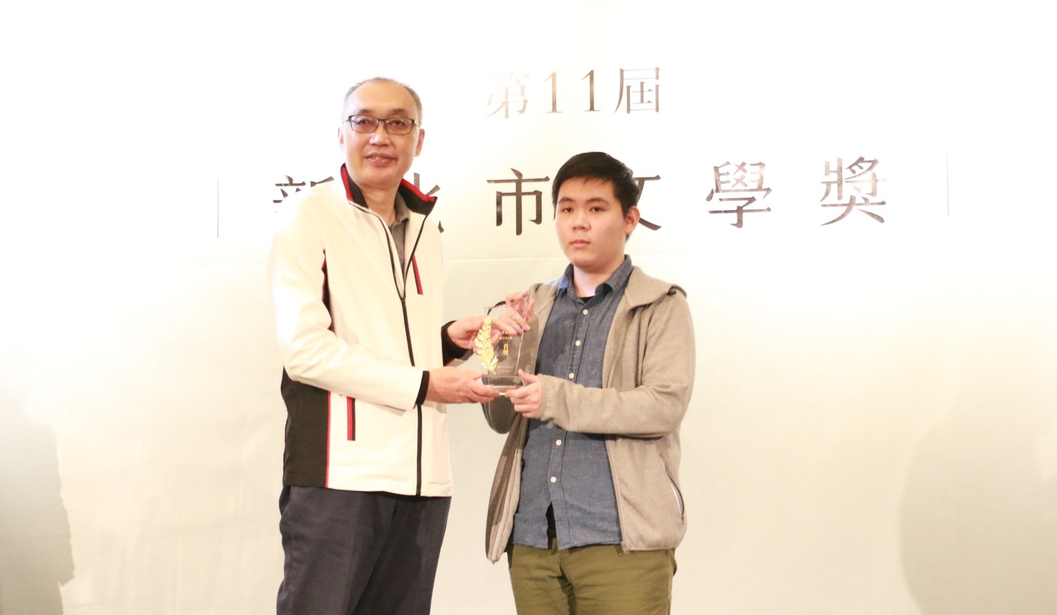 新北副市長謝政達(左)頒發散文青春組首獎予得獎者崔嘉元的親友代領。   圖：新北市文化局提供