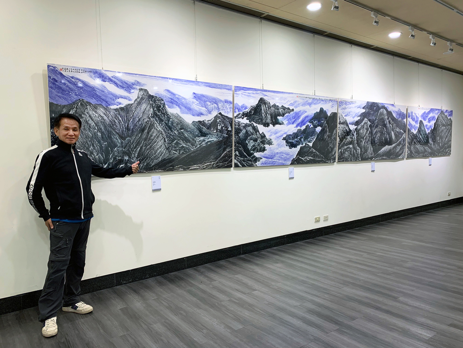 藝術家廖恒運與作品〈中央山脈〉合影。   圖：新北市文化局提供